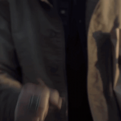 Man In Brown Jacket Holding Green Light GIF