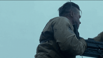 Man In Brown Jacket Holding Machine Gun GIF