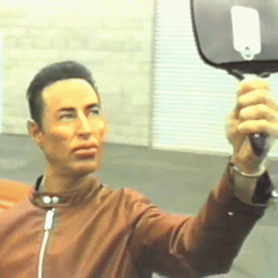 Man In Brown Jacket Holding Mirror GIF