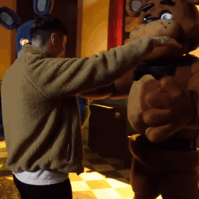 Man in Brown Jacket Hugging Teddy Bear Costume