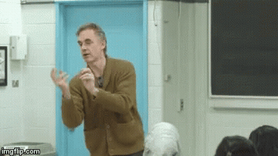 Man In Brown Jacket Lecturing At Blue Door GIF