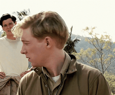 Man In Brown Jacket Looking Side With Man Behind GIF