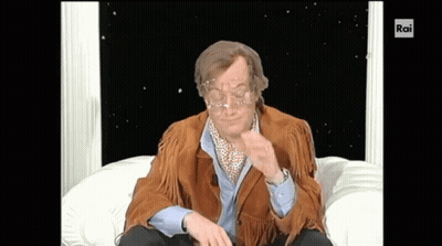 Man In Brown Jacket Sitting On White Couch With Rai GIF