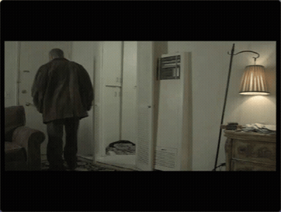 Man In Brown Jacket Standing In Living Room GIF