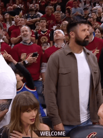 Man In Brown Jacket Welcomes Crowd GIF