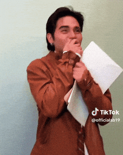 Man In Brown Shirt And Tie Holding Paper GIF