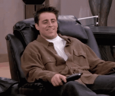 Man In Brown Shirt Holding Remote GIF