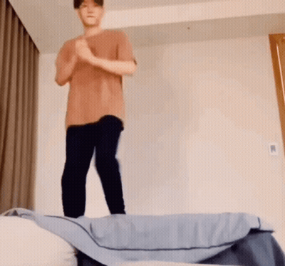Man In Brown Shirt Jumping Off Bed GIF