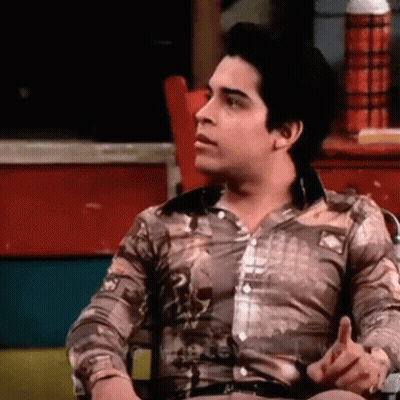 Man In Brown Shirt Sitting And Talking GIF