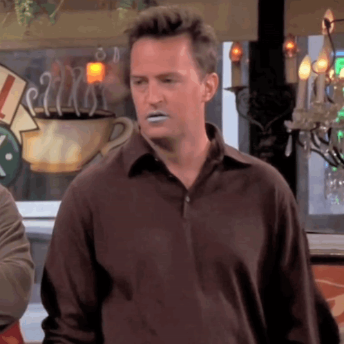 Man In Brown Shirt With Coffee At Window GIF