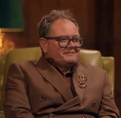 Man In Brown Suit And Glasses Smiling GIF