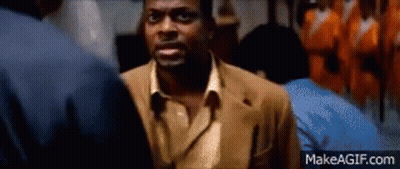 Man In Brown Suit Talking To Another Man In Dark Room GIF