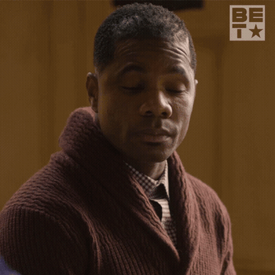 Man In Brown Sweater And Plaid Shirt Smiling In Front Of BET Logo GIF