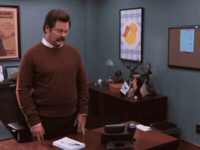 Man In Brown Sweater In Front Of Bulletin Board Saying William's House GIF