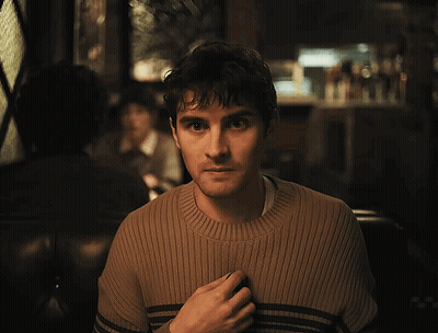 Man In Brown Sweater Looking At Camera GIF