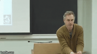 Man In Brown Sweater Presenting At Projector Screen GIF