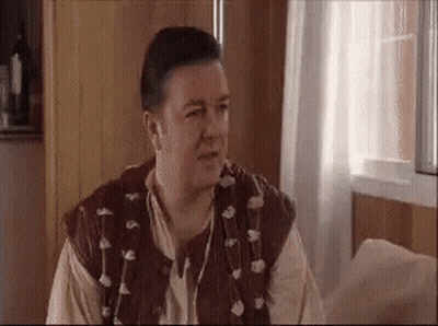 Man In Brown Vest Sitting By Window GIF