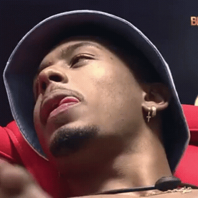 Man In Bucket Hat And Earrings Sitting In Chair GIF