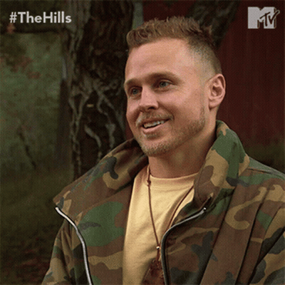 Man In Camo Jacket Smiling In Front Of Red Barn GIF