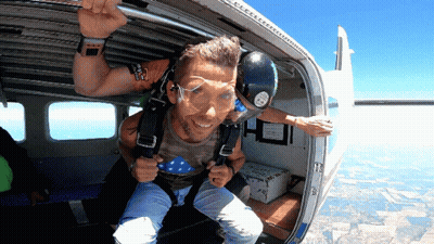 Man In Camo Shirt Exiting Plane With Emergency Exit Sign GIF