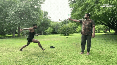 Man In Camo Shirt Throwing Frisbee Another Man Watches GIF