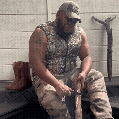 Man In Camo Vest Cutting Log GIF