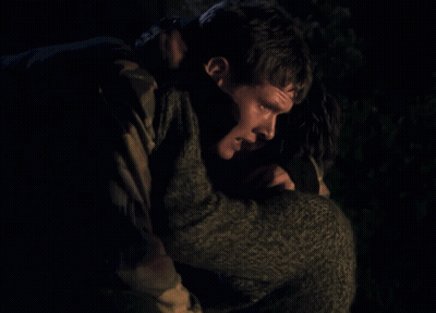 Man In Camouflage Jacket Holding Woman In Dark Room GIF