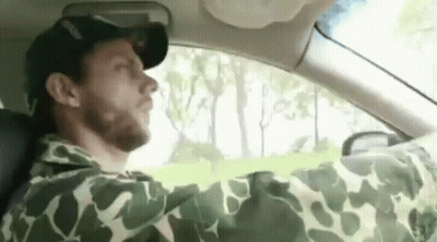 Man In Camouflage Yawning While Driving GIF