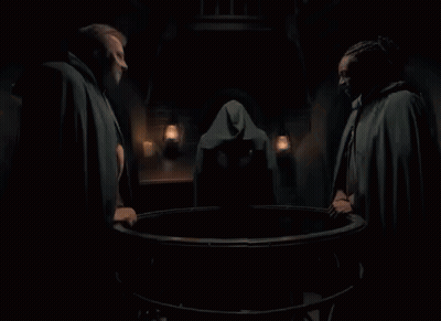 Man In Cape Laughing In Dark Room With Lanterns GIF