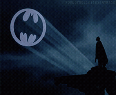 Man In Cape Standing Before Batman Symbol GIF