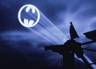 Man In Cape Standing Before Batman Symbol GIF
