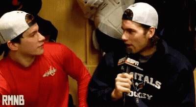 Man In Capitals Sweatshirt Talking Into Microphone GIF