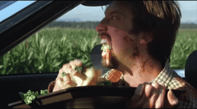 Man In Car Eating Sandwich With Field GIF