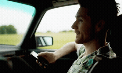 Man In Car Looking At Phone GIF