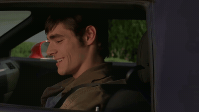 Man in Car Smiling With Red Mirror