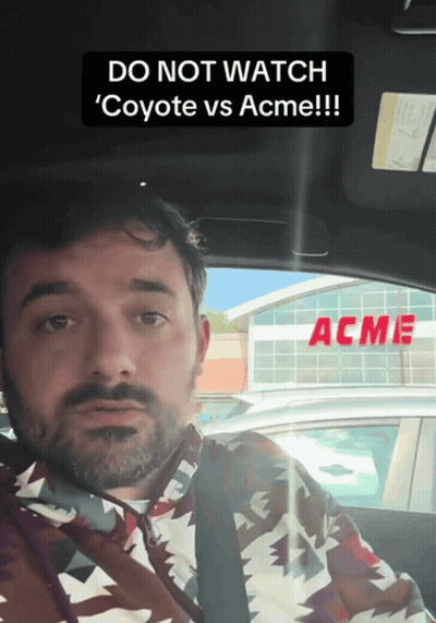 Man In Car With Acme Sign GIF