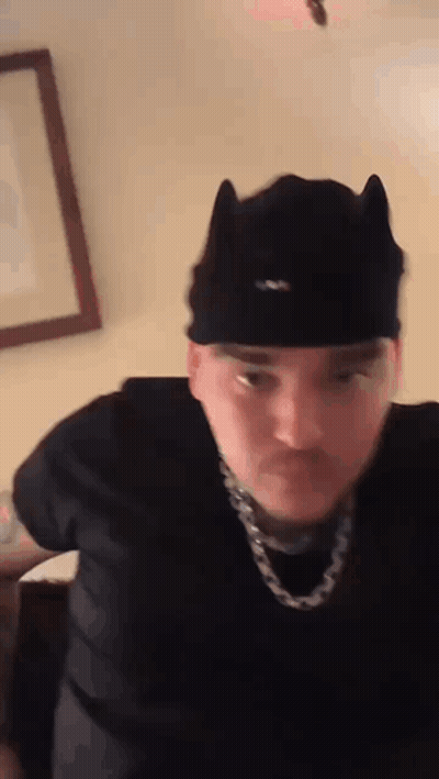 Man In Cat Ear Hat And Chain Making Funny Face GIF