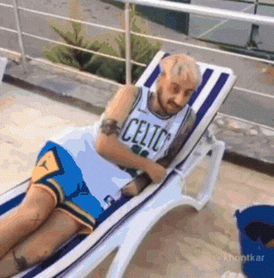 Man in Celtics Jersey Laying on Chair