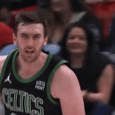 Man In Celtics Jersey Stands In Front Of Seated Woman GIF