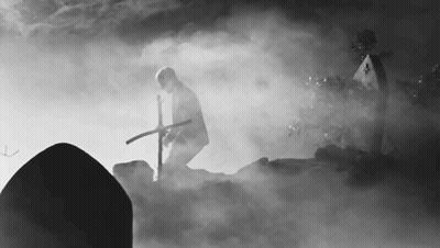 Man In Cemetery Holding Cross GIF