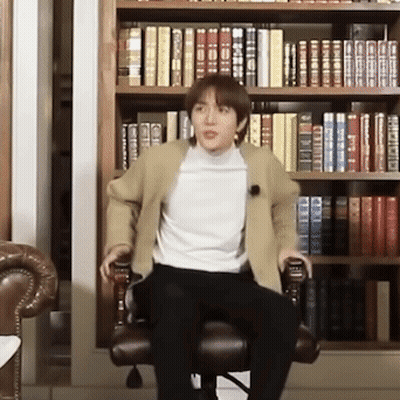 Man In Chair By Bookshelf GIF