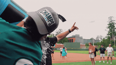 Man In Champs Hat Being Poured With Water GIF