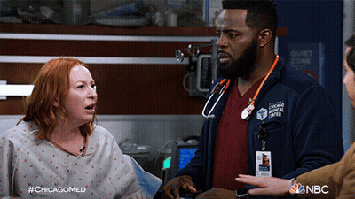 Man In Chicago Medical Center Jacket Talks To Woman GIF