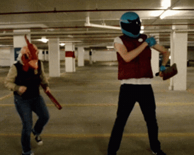 Man In Chicken Mask Next To Man In Blue Helmet GIF