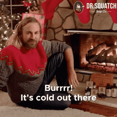 Man In Christmas Sweater By Fireplace Saying It's Cold Out There GIF