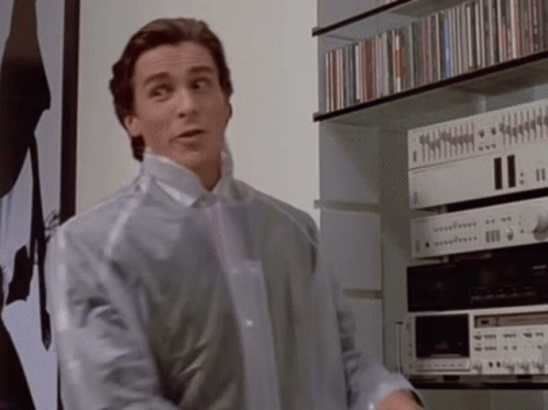 Man In Clear Plastic Jacket In Front Of CD Shelf GIF