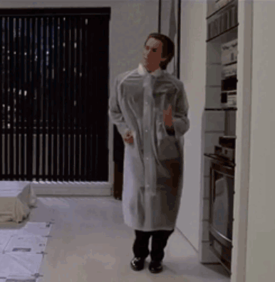 Man In Clear Raincoat In Kitchen GIF