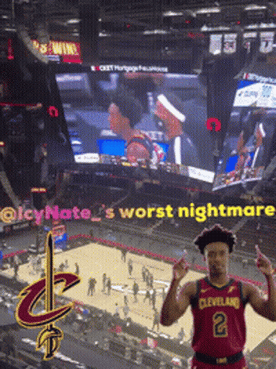 Man In Cleveland Jersey In Front Of Large Screen GIF