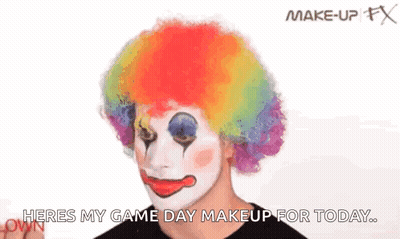Man In Clown Wig Applying Makeup GIF