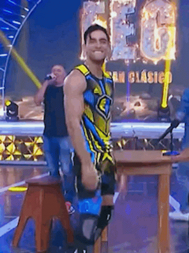 Man In Colorful Costume On Stage With Microphone GIF